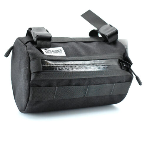 A photograph showcasing the Road Runner Bags Burrito Supreme bike handlebar bag. This compact, cylindrical bag is mounted on the handlebars of a bicycle, providing convenient and easily accessible storage for cyclists. The durable design, coupled with weather-resistant materials, ensures reliable protection for essentials such as snacks, gadgets, or small personal items during rides. The bag is securely fastened to the handlebars, offering a streamlined and stylish addition to the bike's accessories.
