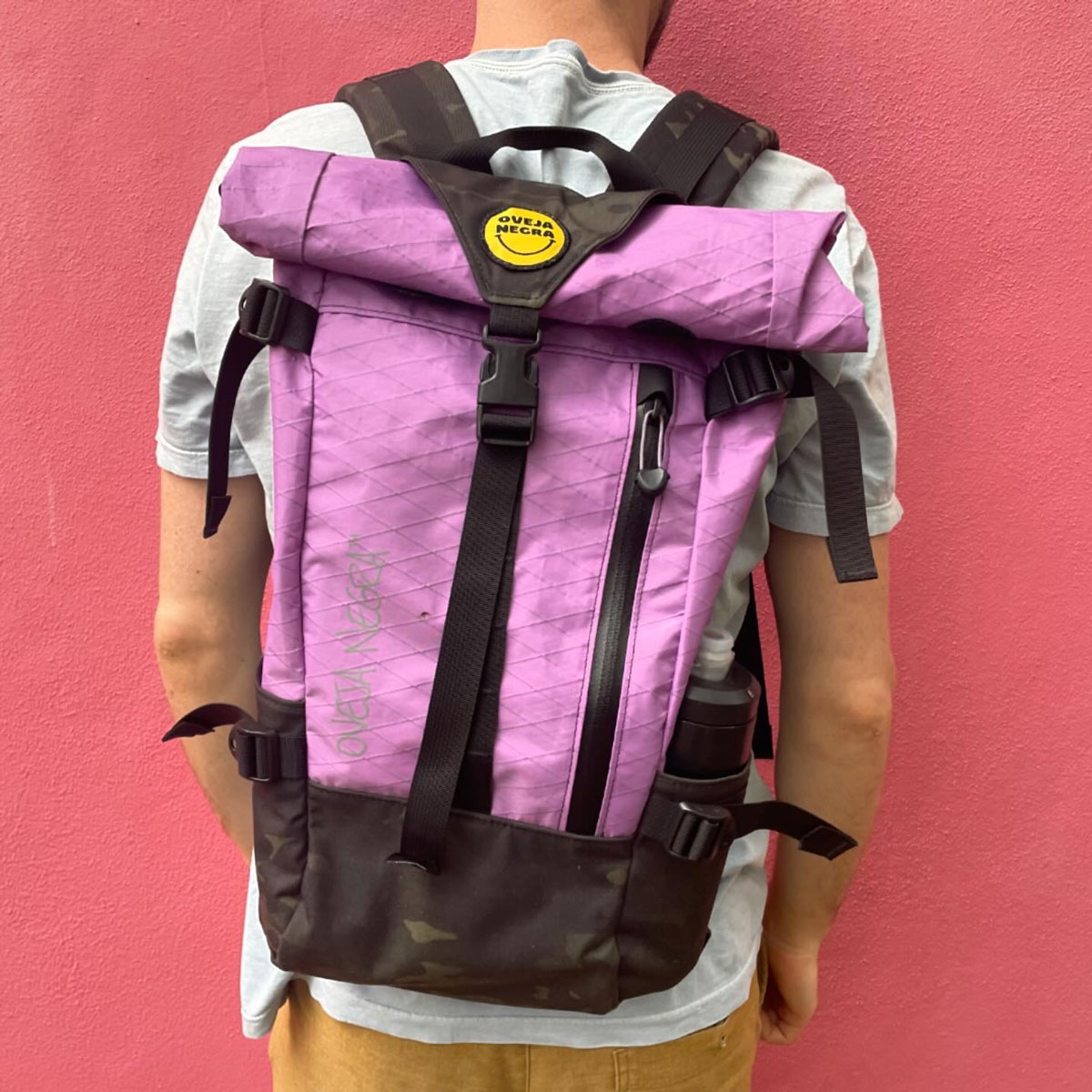 A person wearing the Oveja Negra Portero Backpack, standing confidently in an urban setting, showcasing the backpack's stylish design and functional features.